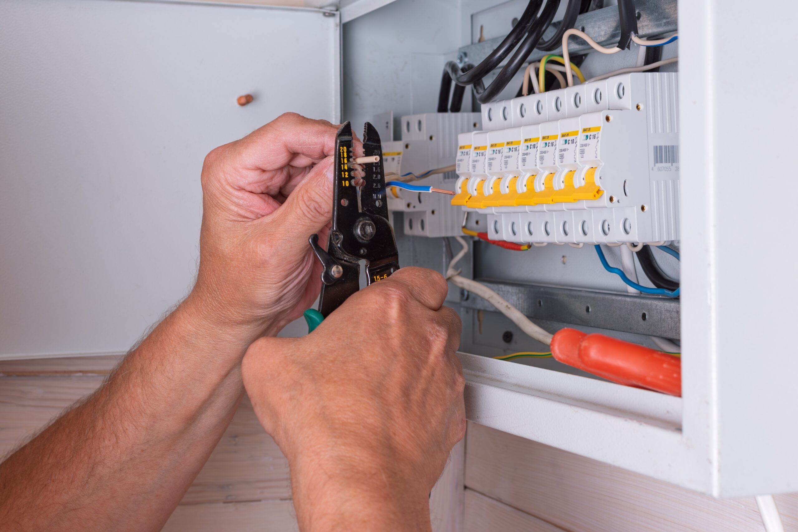 Electrician inspecting failing electrical circuits in a residential electrical panel